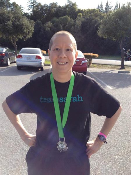 A photo of a woman with a race medal.