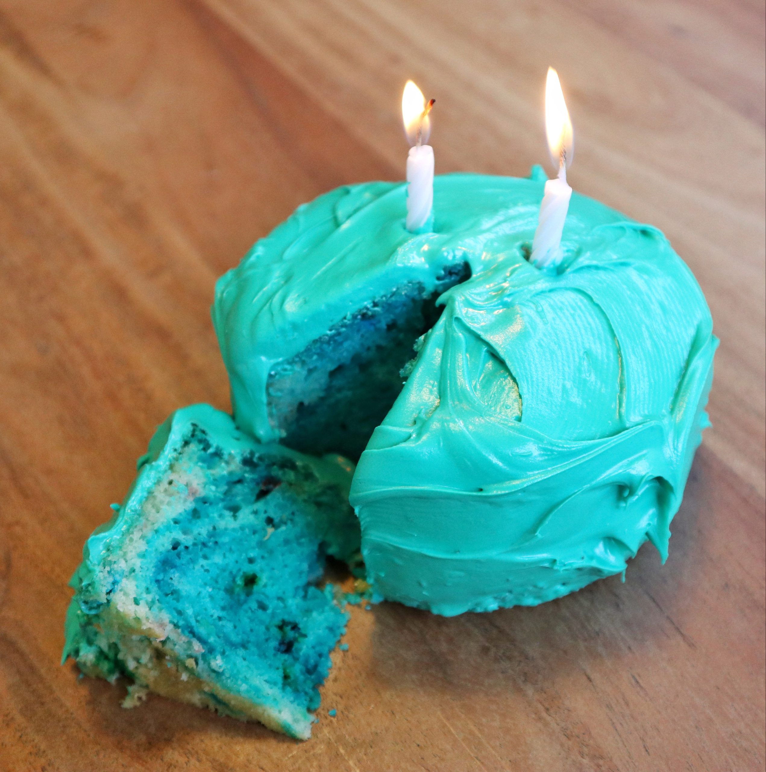 A cake frosted in Truveta teal, with two candles.