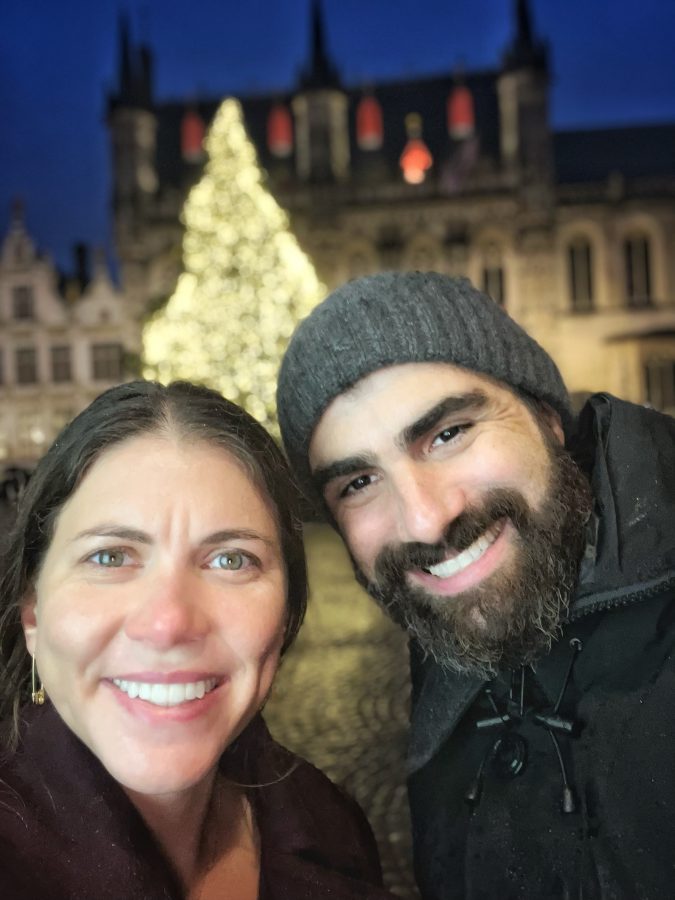 A couple in front of a brightly lit Christmas tree in Bruges